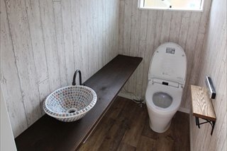 トイレ／床も壁もビンテージウッド。オーダーメイドの杉の一枚板のカウンターの上にはモザイクタイルの手洗器があります。