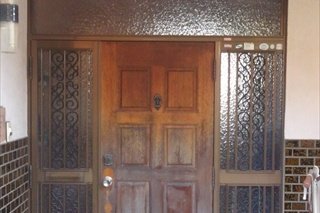 【施工前】日焼け雨ざらしによってひどく傷んだ木製の玄関ドアでした。