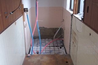 【施工中】浴槽を外すと、やはり土台が腐り、つぶれていました。シロアリにも食われていました。土台補強し、床に透湿防水シートを張ります。その上に、システムバスを据え付けるために鉄筋を組んで、そして生コンを打ちます。